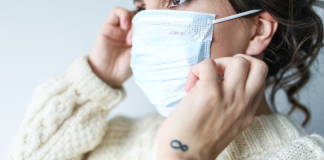 Muller colocando unha máscara quirúrxica antes de sair da casa | Foto Pixabay