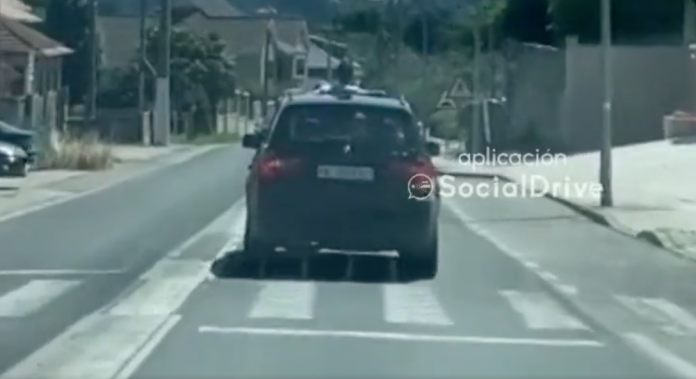 Conducindo con parte do corpo asomando polo teito en Aldán | Foto Social Drive